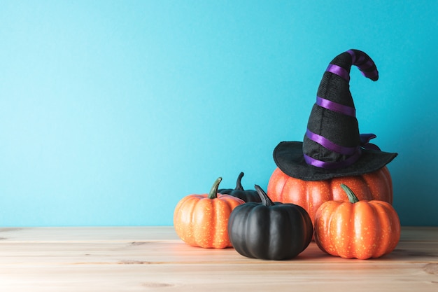 Decoración de calabaza de Halloween y sombrero de bruja en mesa de madera