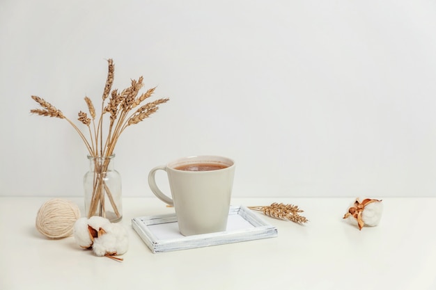 Decoración casera ecológica natural con vela de taza de café en bandeja de madera. Fondo de estilo de vida de desayuno temprano en la mañana. Decoración de interiores con taza de bebida caliente. Espacio de copia de concepto de estilo escandinavo de Hygge