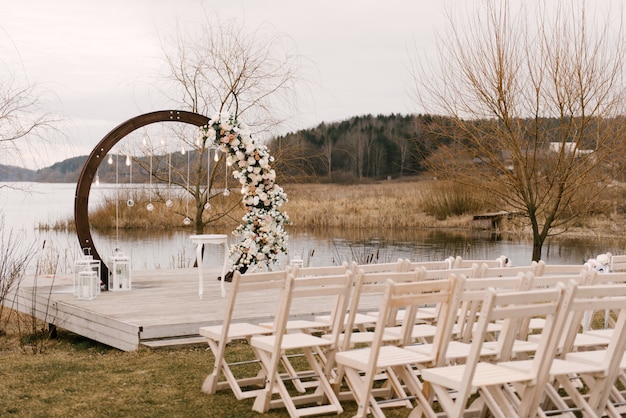 Decoración de ceremonia de boda con arco de madera con flores.