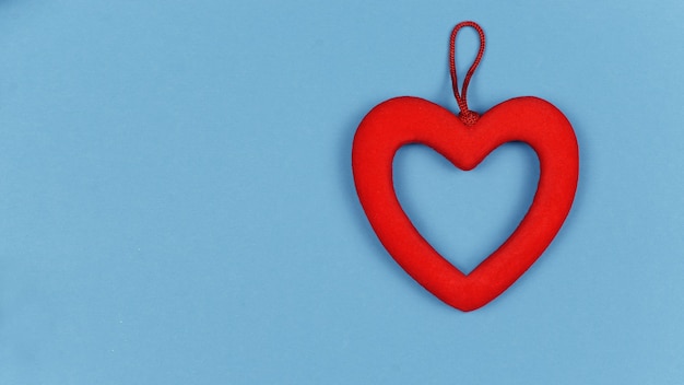 Decoración de corazón rojo para la fiesta del amor el Día de San Valentín y la boda sobre un fondo azul.