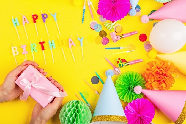 Foto decoración de cumpleaños en la vista superior de fondo amarillo plantilla de maqueta de estilo plano laico con espacio de copia