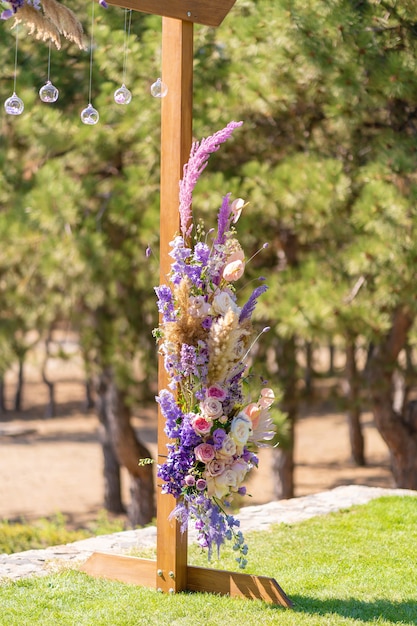 Decoración decorativa del arco de la boda con flores frescas. Celebrando una ceremonia de boda al aire libre. Detalles decorativos
