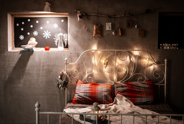 Decoración de dormitorio navideño en estilo loft, gris concreto y palo con regalos colgados en la pared.