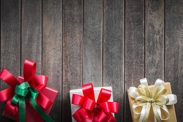 Foto decoración especial de caja de regalo en un piso de madera antiguo con cinta para agregar el concepto de mensaje de texto de navidad y año nuevo o tarjeta de felicitación día de san valentín