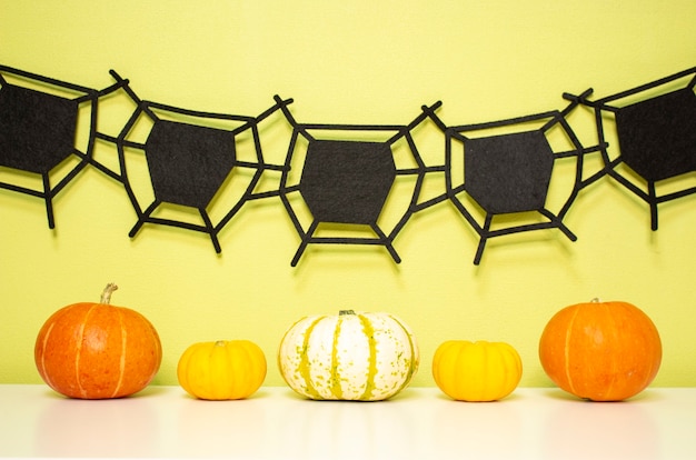 Foto decoración festiva de halloween con telarañas y calabazas sobre la mesa. actitud festiva