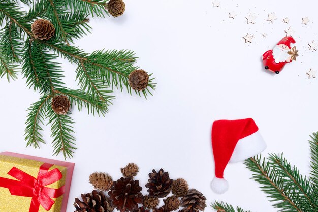 Decoración festiva de navidad sobre un fondo blanco Ramas de abeto piñas caja de regalo estrellas vista superior