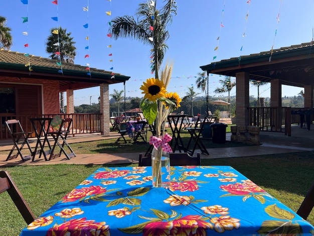 Decoración de fiesta junina con flores, sombreros, carreta de caballos, heno y corazón para tomar fotos.