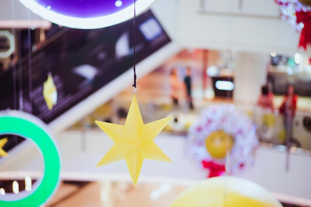 Foto decoración en forma de estrella amarilla colgada en un centro comercial