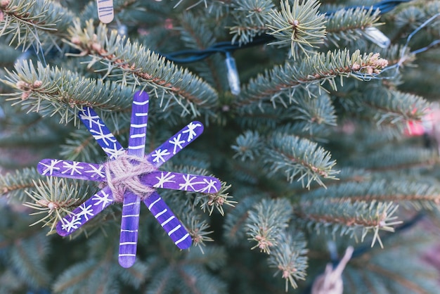 Decoración hecha a mano de bricolaje hecha de palos artesanales en el árbol de Navidad