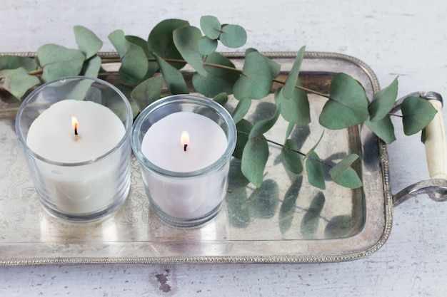 Decoración del hogar con hojas verdes y velas encendidas sobre la mesa.