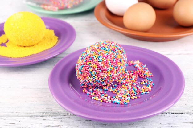 Decoración huevos de Pascua con cuentas de colores en primer plano de la mesa de madera