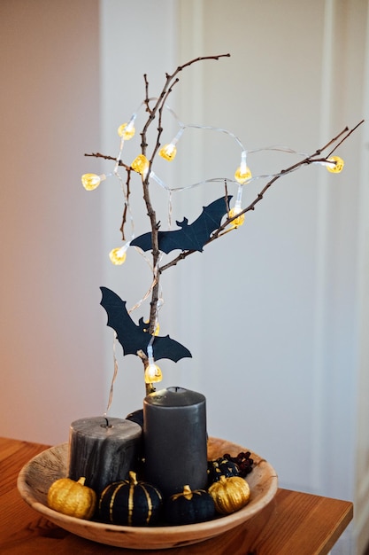 Decoración interior de Halloween con murciélagos de papel de calabazas negras y guirnaldas ligeras Interior oscuro decorado para velas de calabazas de Halloween y murciélagos en la mesa