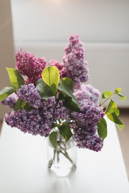 Decoración interior del hogar ramo de lilas en un jarrón sobre la mesa