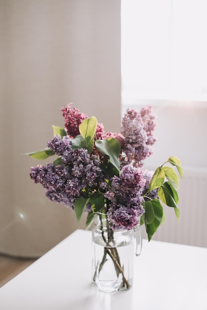 Decoración interior del hogar ramo de lilas en un jarrón sobre la mesa