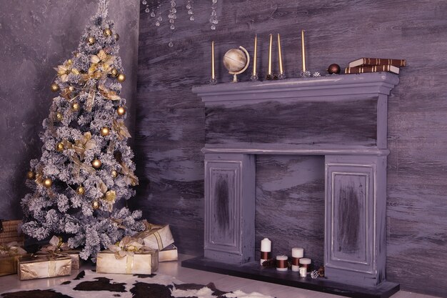 Decoración interior de Navidad con cajas de Navidad, chimenea y árbol.