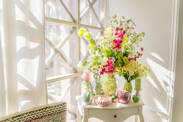 Decoración interior de Pascua. Hermosa composición con velas. huevos, conejos, manzanas y flores florecientes.