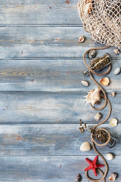 Decoración de interiores de verano con estrellas de mar, conchas, cuerdas y botellas con piedras sobre fondo de madera azul. Copie el espacio. Naturaleza muerta. Endecha plana