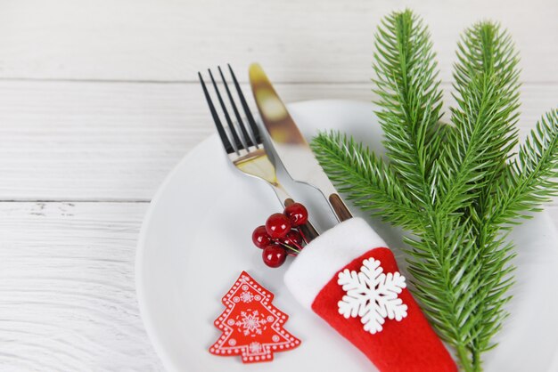 Decoración de lugar de mesa de Navidad con tenedor cuchillo en sombrero de santa claus y pino en plato blanco Navidad Año Nuevo comida almuerzo festivo cena de Navidad vacaciones