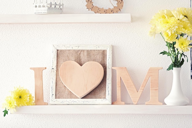 Decoración de madera y flores para el día de la madre en un estante.