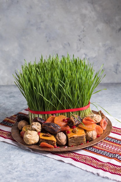 Decoración de la mesa de ajuste de Novruz, pasto de trigo, pastelería nacional de Azerbaiyán pakhlava, celebración de año nuevo sring, despertar de la naturaleza