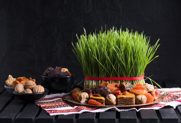 Decoración de la mesa de ajuste de Novruz, pasto de trigo, pastelería nacional de Azerbaiyán pakhlava, celebración de año nuevo sring, despertar de la naturaleza