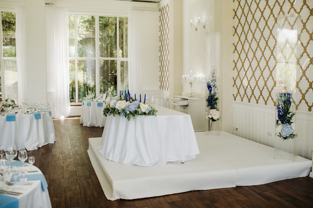 Decoración de la mesa de boda con flores azules en la mesa en la decoración de la mesa del restaurante para la cena en la boda