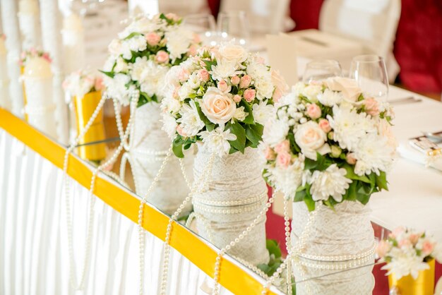 Decoración de mesa de boda con flores y cristalería.