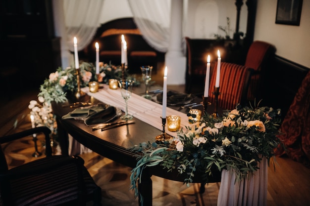 Decoración de mesa de boda con flores sobre la mesa en el castillo, decoración de mesa para cenar a la luz de las velas.Cena con velas.