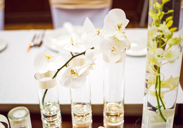 Decoración de mesa de boda con orquídeas y cristalería.