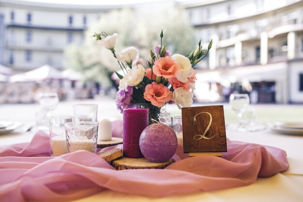 Decoración de mesa festiva de restaurante con flores y velas.