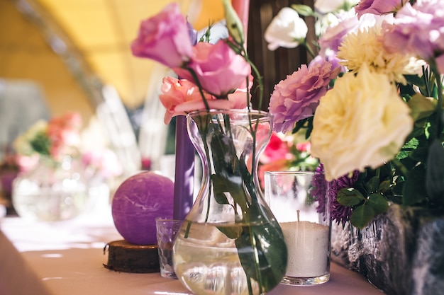 Decoración de mesa festiva de restaurante con flores y velas.