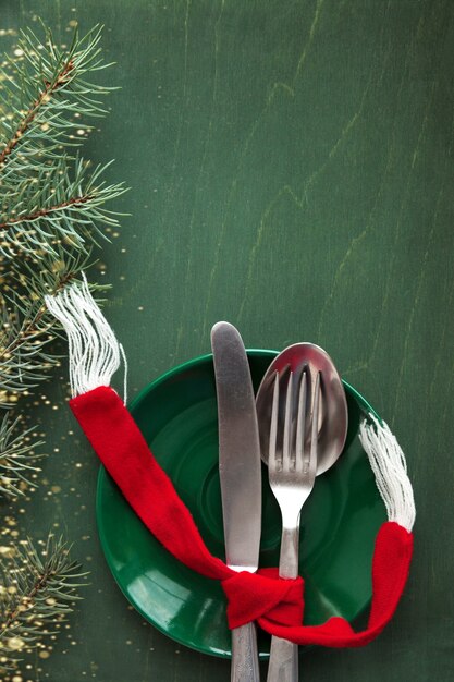 Decoración de mesa navideña sobre un fondo verde con una ramita de abeto como elemento de diseño de menú