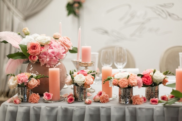 Decoración para la mesa de vacaciones. Portavelas de flores naturales en colores rosados.