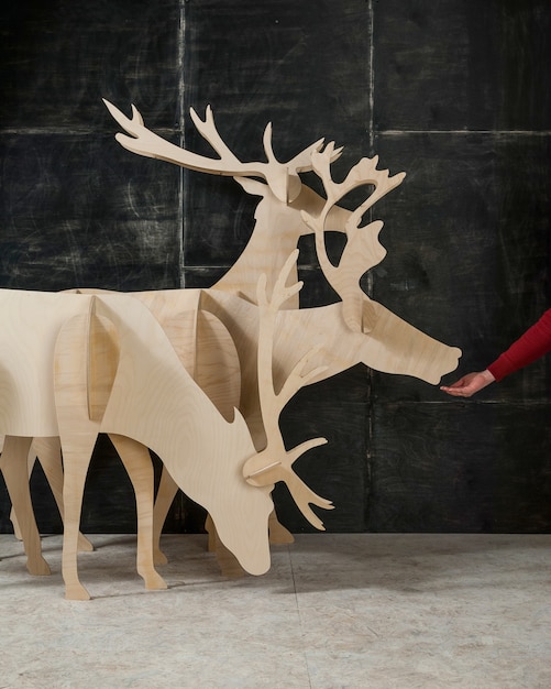 Foto decoración de navidad y año nuevo ciervos de madera contrachapada y madera sobre un fondo oscuro