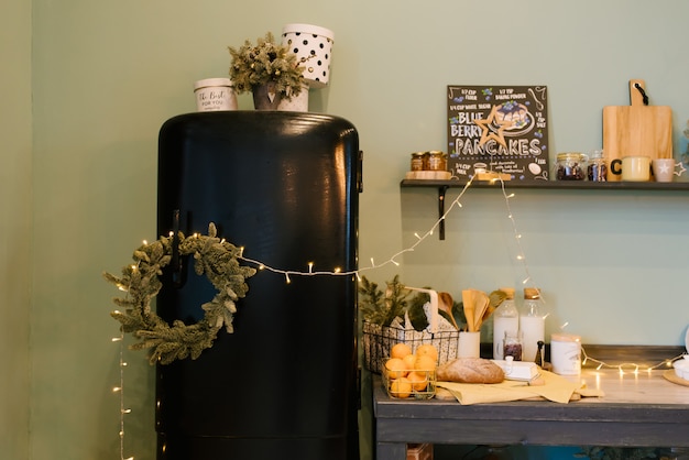 Foto la decoración de navidad y año nuevo. cocina con refrigerador retro negro