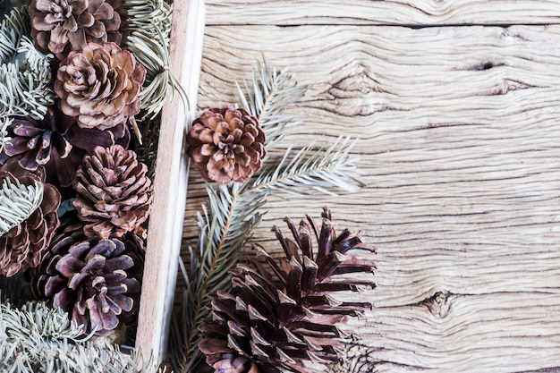 Decoración de Navidad de conos de pino en caja de madera