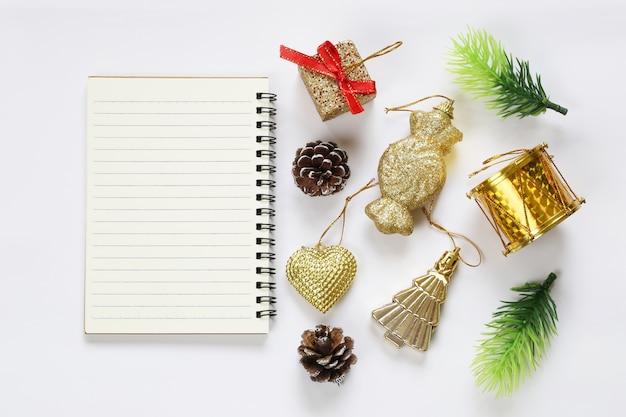 Decoración de la Navidad y cuaderno vacío en el fondo blanco.