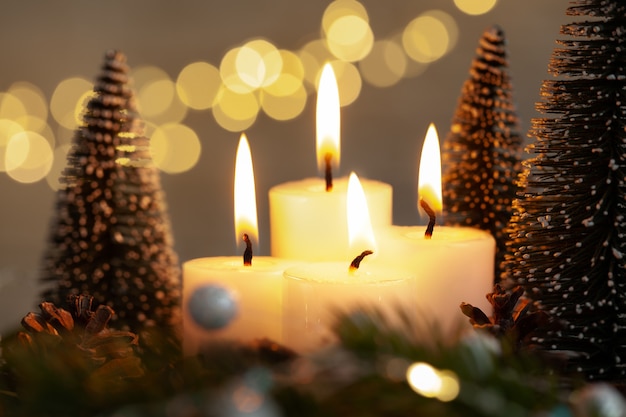 Foto decoración de navidad cuatro luces de velas encendidas en la víspera de navidad. símbolo de un ritual religioso en época navideña.