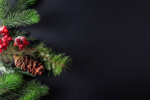 Decoración de Navidad fondo negro con ramas de pino y cono