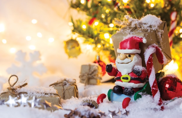 Decoración de Navidad santa claus y caja de regalo en la nieve con luz bokeh