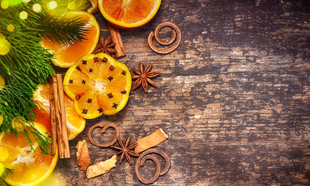 Decoración navideña con abeto, naranjas, conos, nueces, especias en una mesa de madera