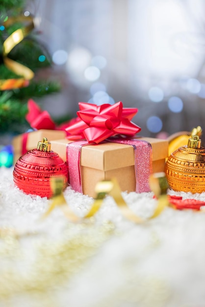 Decoración navideña con adornos de bolas en un árbol de Navidad con cajas de regalo y serpentinas