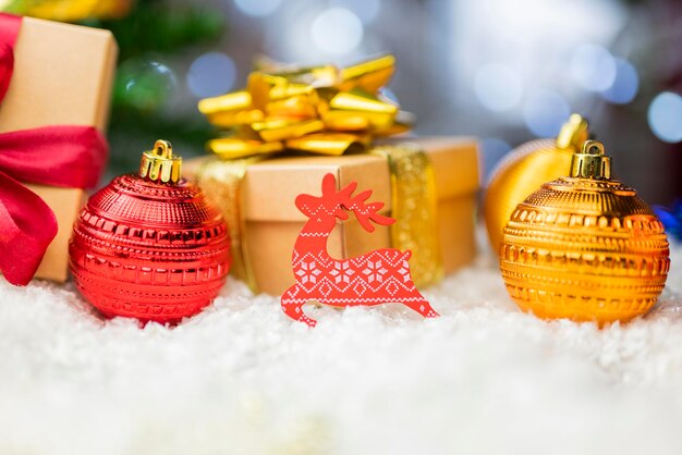 Decoración navideña con adornos de bolas en un árbol de Navidad con cajas de regalo y serpentinas