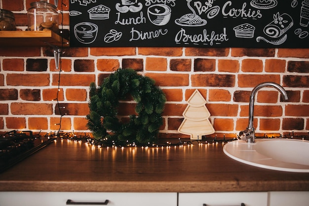 Foto decoración navideña. adornos navideños en la cocina con una corona de ramas de abeto. plato de árbol de navidad