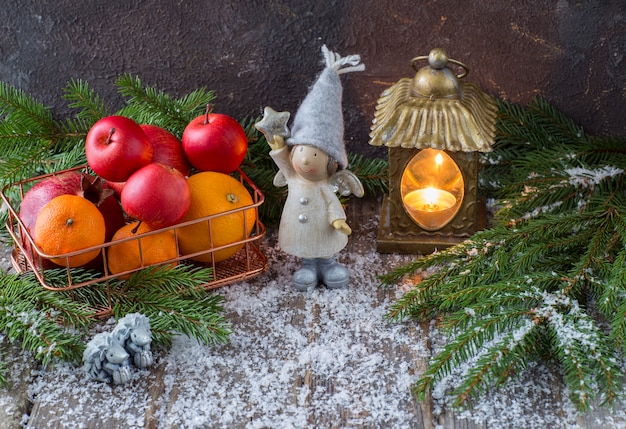 Decoración navideña con angel de juguete y una cesta de frutas