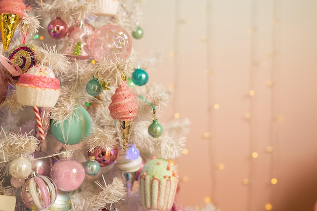 Decoración navideña en el árbol en colores rosa claro.