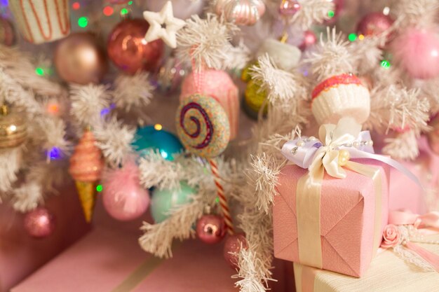 Decoración navideña en el árbol en colores rosa claro.