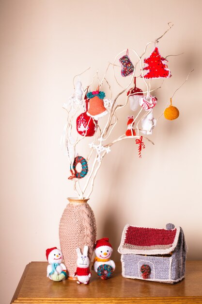 Decoración navideña artesanal en las ramas sobre la pared