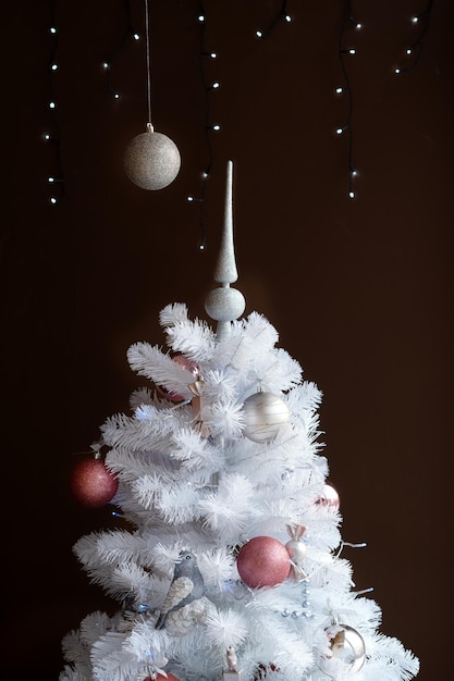 Decoración navideña blanca con bolas en ramas de abeto