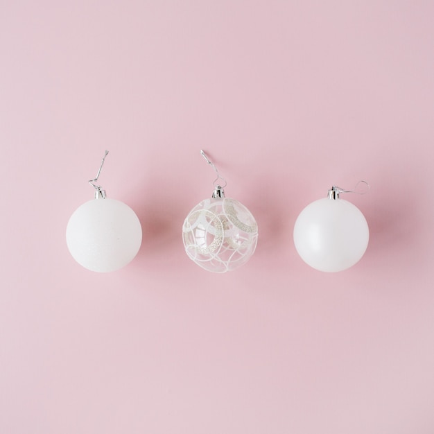 Foto decoración navideña: bolas navideñas de cristal blanco sobre rosa